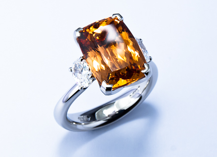Four claw three stone platinum ring with an Imperial topaz and oval diamonds